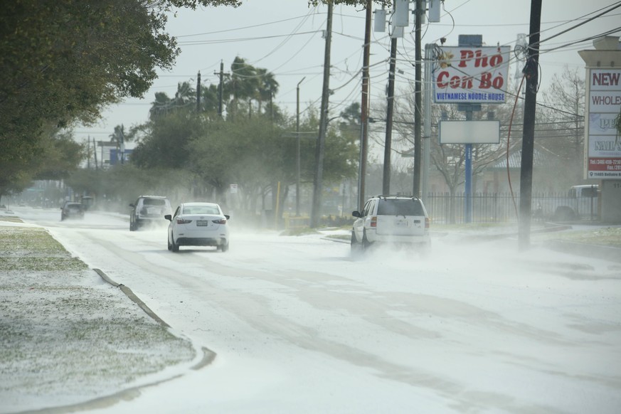 210215 -- HOUSTON, Feb. 15, 2021 -- Vehicles move on a snow-capped road in Houston, Texas, the United States, on Feb. 15, 2021. Up to 2.5 million customers were without power in the U.S. state of Texa ...