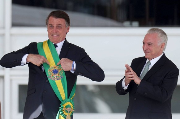 (190101) -- BRASILIA, Jan. 1, 2019 -- Photo provided by Agencia Estado shows Brazil s new President Jair Bolsonaro (L) pointing at the presidential sash after receiving it from outgoing President Mich ...