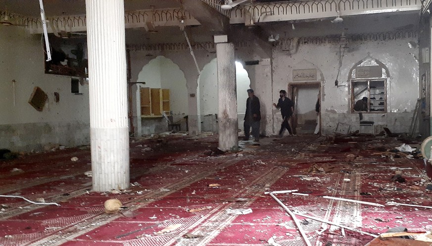 Volunteers examine the site of explosion inside a Shiite mosque in Peshawar, Pakistan, Friday, March 4, 2022. A powerful bomb exploded inside a Shiite Muslim mosque in Pakistan&#039;s northwestern cit ...