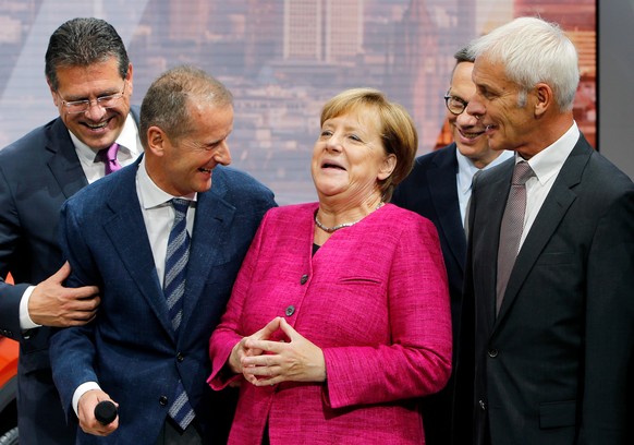 FILE - In this Sept. 14, 2017 file photo German Chancellor Angela Merkel, center, smiles together with VW group CEO Matthias Mueller, right, and VW Cars CEO Herbert Diess, 2nd left, as she arrives at ...