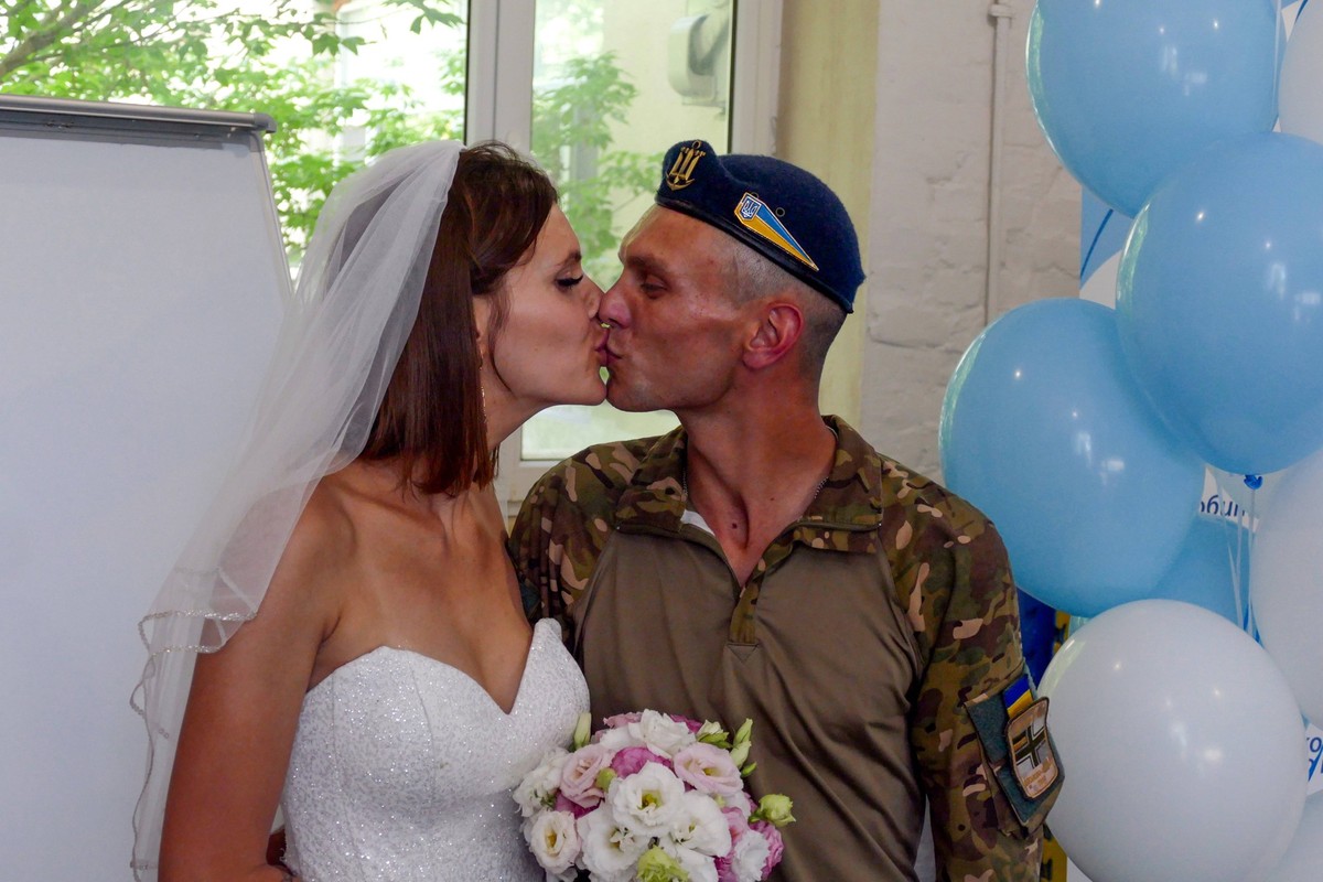 ODESA, UKRAINE - JULY 24, 2023 - Valentyna Fedenko and Vladyslav Davydenko who are both defending Ukraine from Russian occupiers share a kiss during their wedding ceremony at the Mriia family centre, ...