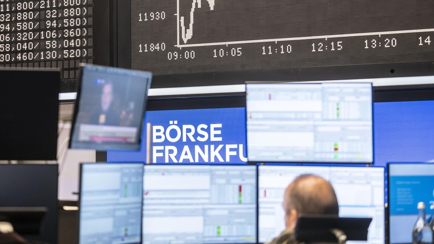Ein Händler sitzt im Handelssaal der Frankfurter Börse vor der Dax-Kurve und seinen Monitoren, auf denen auch Berichte über die US-Präsidentschaftswahl laufen. +++ dpa-Bildfunk