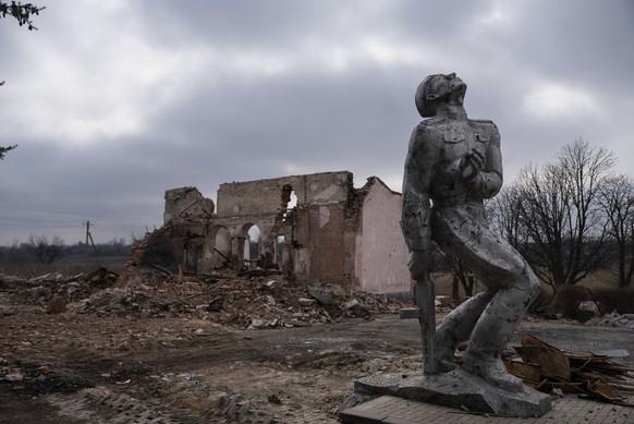 A Soviet-era monument dedicated to the servicemen of World War II stands in front of a destroyed house of culture near Avdiivka, Donetsk region, Ukraine, Thursday, March 21, 2024. (AP Photo/Alex Baben ...