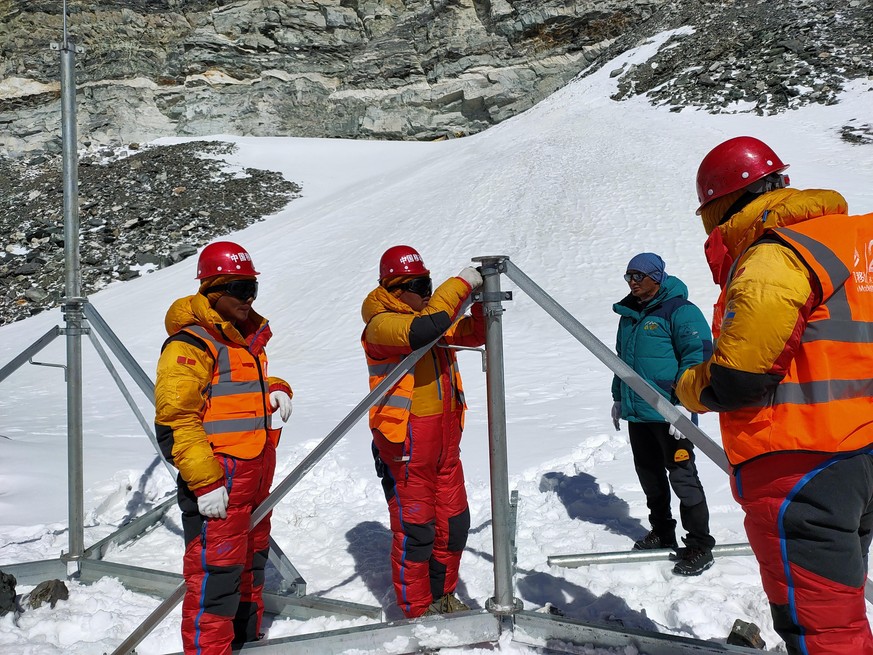 Mitarbeiter von China Mobile installieren in einem Basecamp vom Mount Everest eine 5G-Basisstation.
