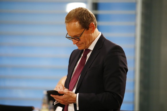 BERLIN, GERMANY - JUNE 17: Berlin Major Michael Mueller uses his phone as he arrives during a meeting with the governors and other leaders of Germany's 16 states at the Chancellery during the novel co ...