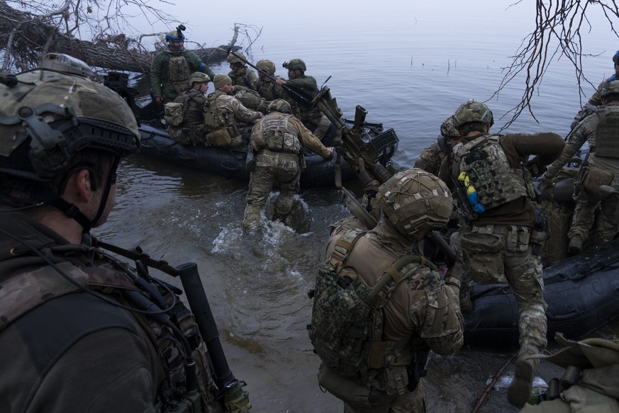 15.10.2023, Ukraine, Cherson: Ukrainische Soldaten steigen in ein Boot am Ufer des Flusses Dnipro an der Frontlinie nahe Cherson. Foto: Mstyslav Chernov/AP/dpa +++ dpa-Bildfunk +++