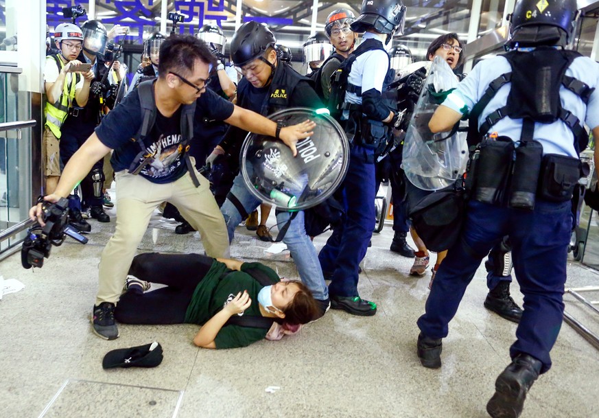 Riot police disperse anti-extradition bill protesters during a mass demonstration after a woman was shot in the eye, at the Hong Kong international airport, in Hong Kong China August 13, 2019. REUTERS ...
