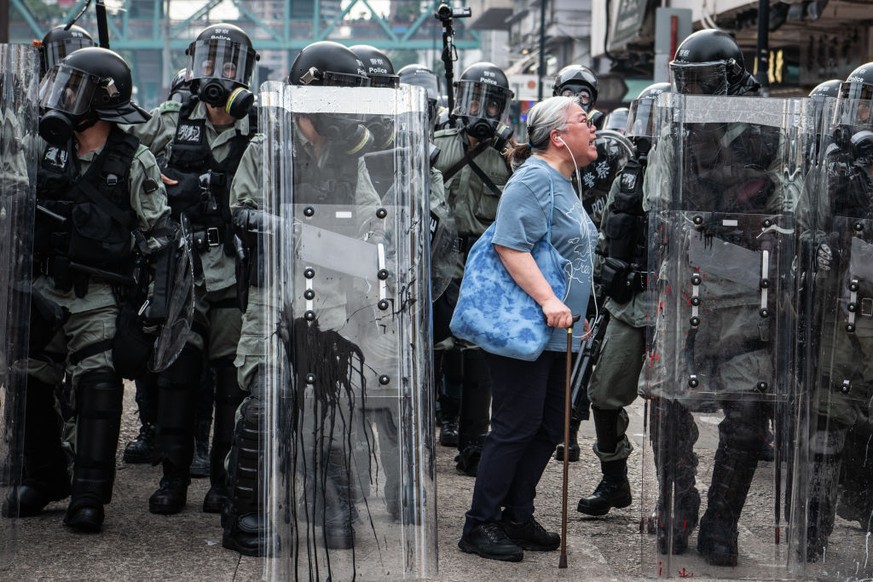 HONG KONG, CHINA - JULY 27: A woman shouts at police officers as they advance towards protesters in the district of Yuen Long on July 27, 2019 in Hong Kong, China. Pro-democracy protesters have contin ...