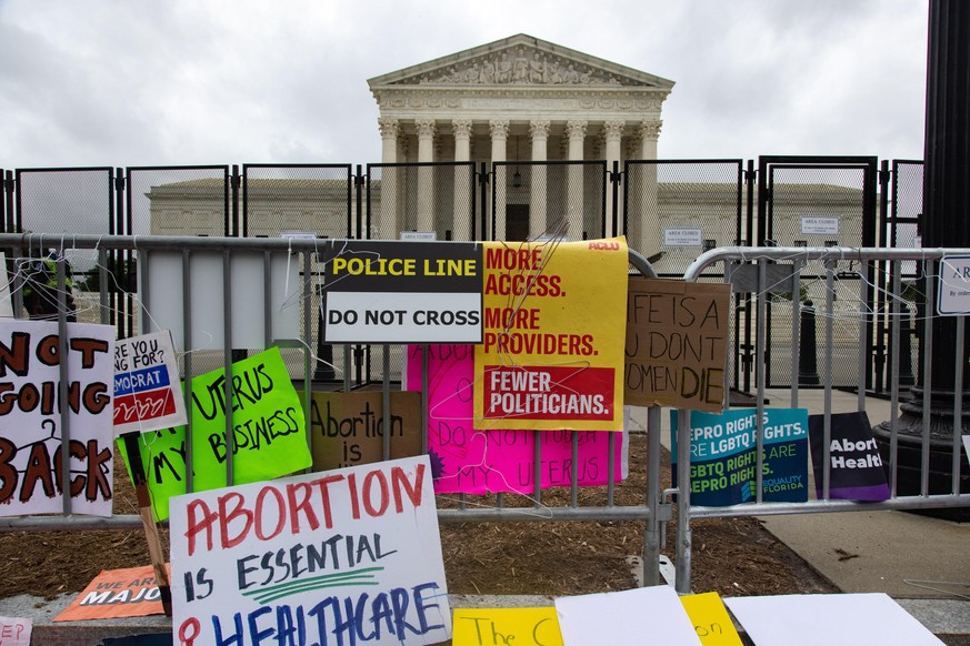 Protest signs and coathangers rest on fencing outside of the Supreme Court after the Bans Off Our Bodies Women's March in Washington, D.C. on May 14, 2022 (Photo by Bryan Olin Dozier/NurPhoto)