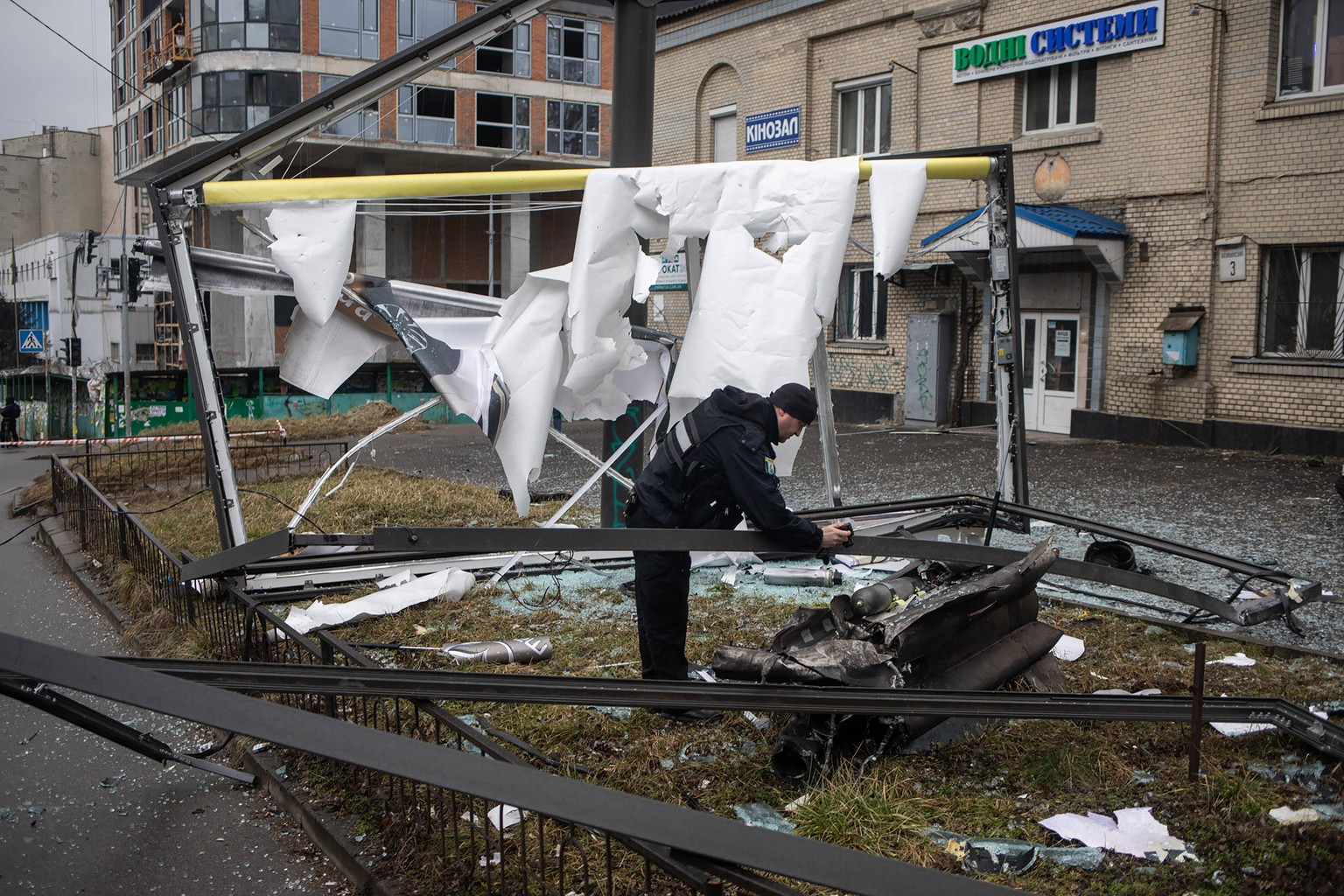 Police and security personnel inspect the remains of a military weapon on a street in Kyiv, Ukraine, Thursday, February 24, 2022. Russia has launched a full-scale invasion of Ukraine, unleashing airst ...