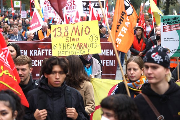 29.10.2022, Hamburg: Eine Frau hält ein Schild mit der Aufschrift &quot;13,8 Millionen sind arm, ich bin armutsbetroffen !&quot; auf einer Demonstration unter dem Motto &quot;Solidarisch aus der Krise ...