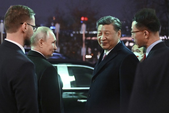 Chinese President Xi Jinping, right, and Russian President Vladimir Putin talk to each other prior to Chinese President Xi Jinping leaving after their dinner at The Palace of the Facets in the Moscow  ...