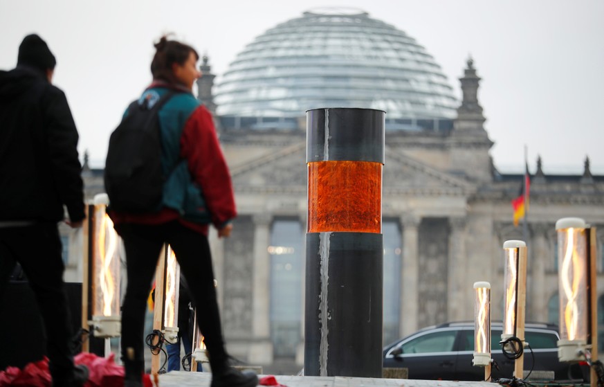 People walk past a temporary memorial, a column dedicated to the victims of the Holocaust, set up by activists of the &#039;Zentrum fuer politische Schoenheit&#039; (Center for Political Beauty) in Be ...