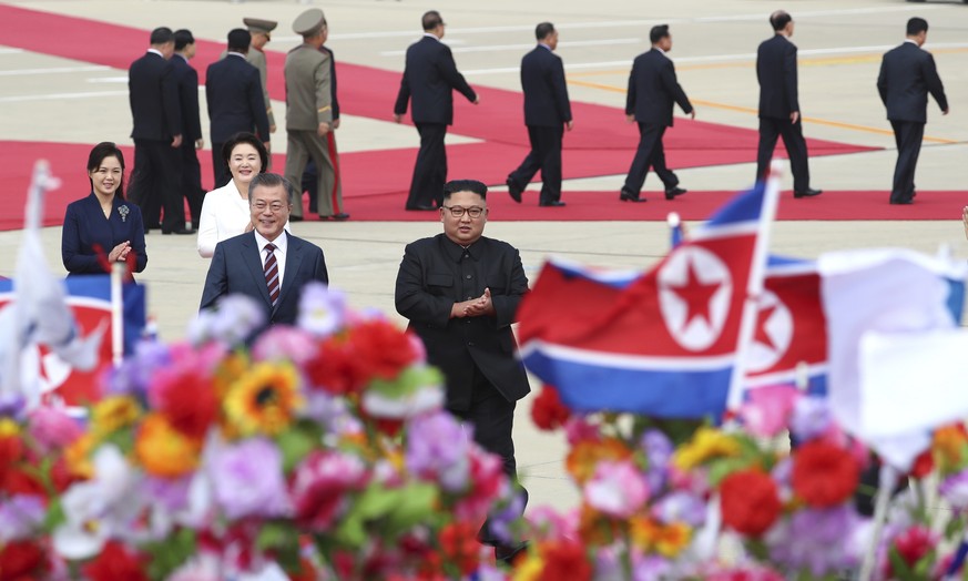 South Korean President Moon Jae-in, front left, walks with North Korean leader Kim Jong Un, front right, upon Moon&#039;s arrival at Sunan International Airport in Pyongyang in North Korea, Tuesday, S ...