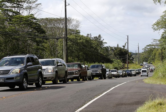 Residents of the Leilani Estates queue in a line to enter the subdivision to gather possessions from their homes, Sunday, May 6, 2018, in Pahoa, Hawaii. Scientists reported lava spewing more than 200 ...