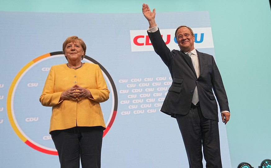 21.08.2021, Berlin: Armin Laschet, Kanzlerkandidat der Union, CDU-Bundesvorsitzender und Ministerpräsident von Nordrhein-Westfalen, steht neben Bundeskanzlerin Angela Merkel (CDU) auf der Bühne beim z ...