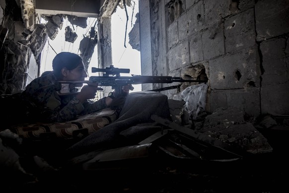 August 12, 2017 - Raqqa, Syria - A YPJ sniper takes high position in a 5 storey building overlooking ISIS position. She says that ISIS uses civilians as human shields to cross open ground..In Summer 2 ...