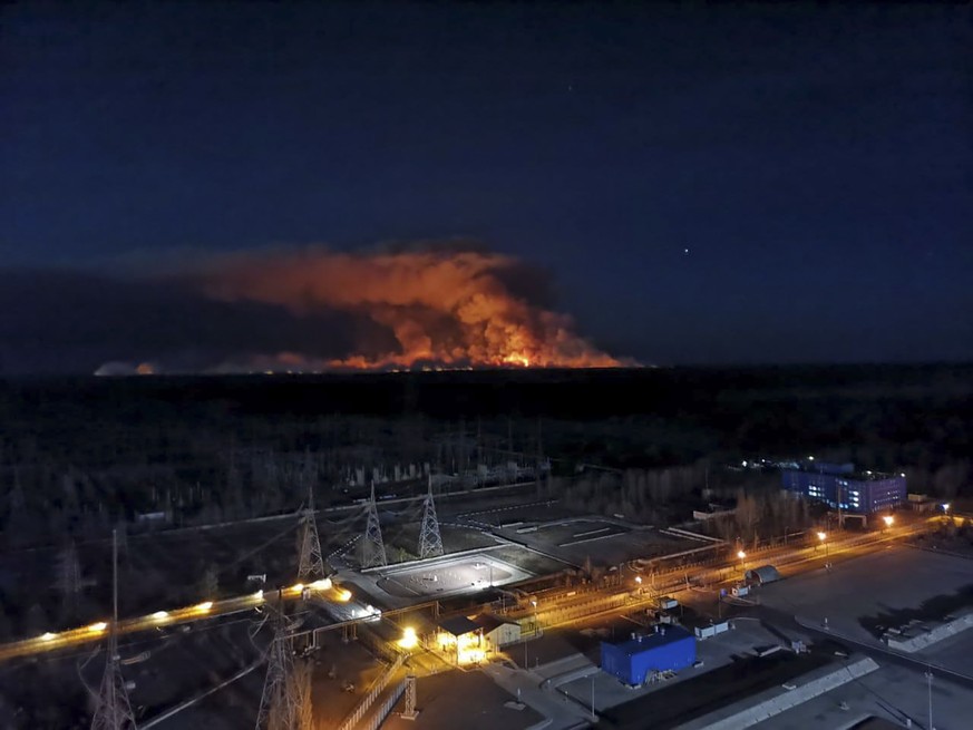 In this photo taken from the roof of Ukraine's Chernobyl nuclear power plant late Friday April 10, 2020, a forest fire is seen burning near the plant inside the exclusion zone. Ukrainian firefighters  ...