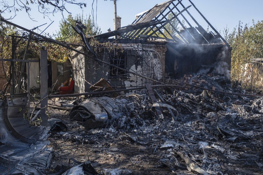 ARCHIV - 05.10.2024, Ukraine, Kostjantyniwka: Ein beschädigtes Haus ist im Hintergrund von Fragmenten eines abgeschossenen russischen Militärflugzeugs am Stadtrand von Kostjantyniwka, einer Stadt nahe ...