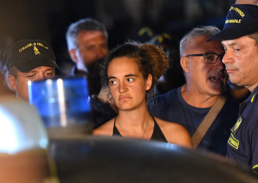 Carola Rackete, the 31-year-old Sea-Watch 3 captain, is escorted off the ship by police and taken away for questioning, in Lampedusa, Italy June 29, 2019. REUTERS/Guglielmo Mangiapane