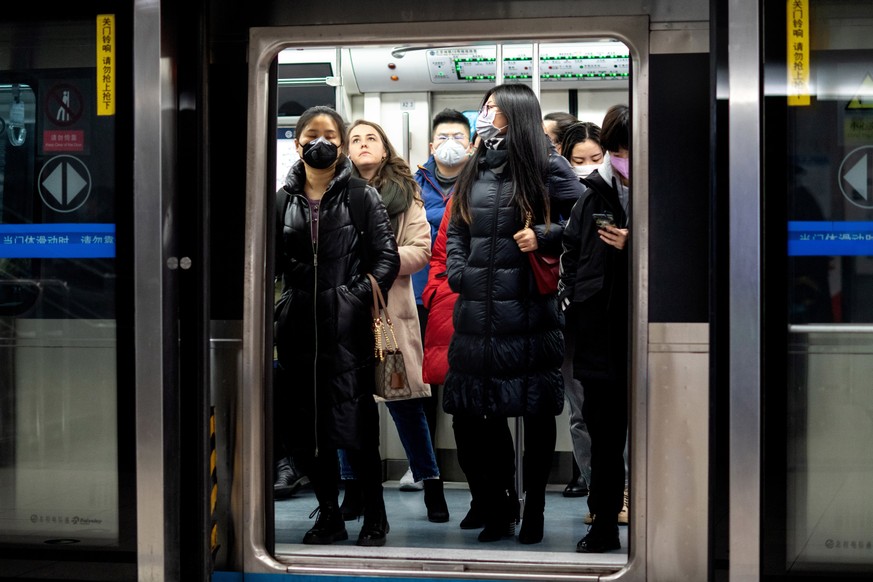 Menschen in der Pekinger U-Bahn. 