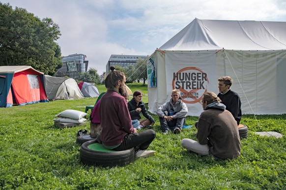 ARCHIV - 02.09.2021, Berlin: Umweltaktivisten sitzen im Regierungsviertel zusammen vor einem Zelt. Berlin (dpa) - Nach zwei Wochen Hungerstreik f�r eine radikale Klimawende haben die Beteiligten in Be ...