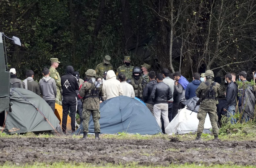 ARCHIV - 01.09.2021, Polen, Usnarz Gorny: Migranten werden von schwer bewaffneten polnischen Sichherheitskr