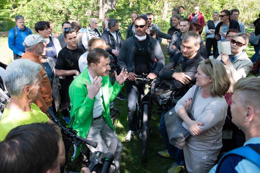 16.05.2020, Sachsen, Dresden: Michael Kretschmer (CDU, M), Ministerpräsident von Sachsen, spricht im Großen Garten mit Anhängern von Verschwörungstheorien zur Corona-Krise. Kretschmer möchte auf der K ...