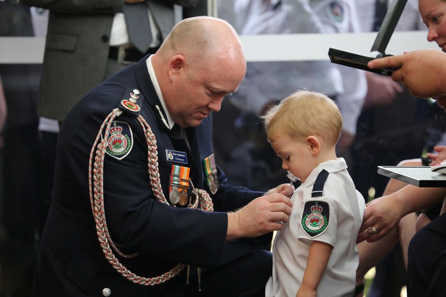 RFS Commissioner Shane Fitzsimmons presents a posthumous Commendation for Bravery and Service to the son of RFS volunteer Geoffrey Keaton at Keaton's funeral in Buxton, New South Wales, Australia Janu ...