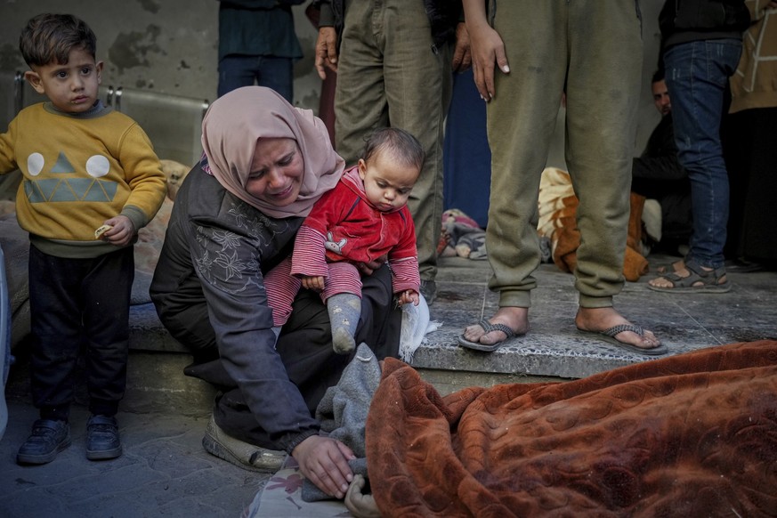 A woman mourns as she identifies a body in the Al-Ahli hospital following overnight Israeli airstrikes across the Gaza Strip, in Gaza City, Tuesday, March 18, 2025. (AP Photo/Jehad Alshrafi)