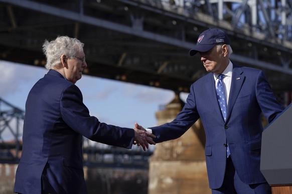 04.01.2023, USA, Covington: Joe Biden (r), Präsident der USA, gibt Mitch McConnell, republikanischer Minderheitsführer im US-Senat, die Hand, nachdem er unter der Clay Wade Bailey Bridge über seine In ...