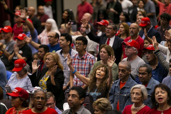 January 3, 2020, Miami, FL, USA: Attendees pray before President Donald Trump speaks at an Evangelicals for Trump campaign rally at the King Jesus International Ministry in Miami on Friday, Jan. 3, 20 ...