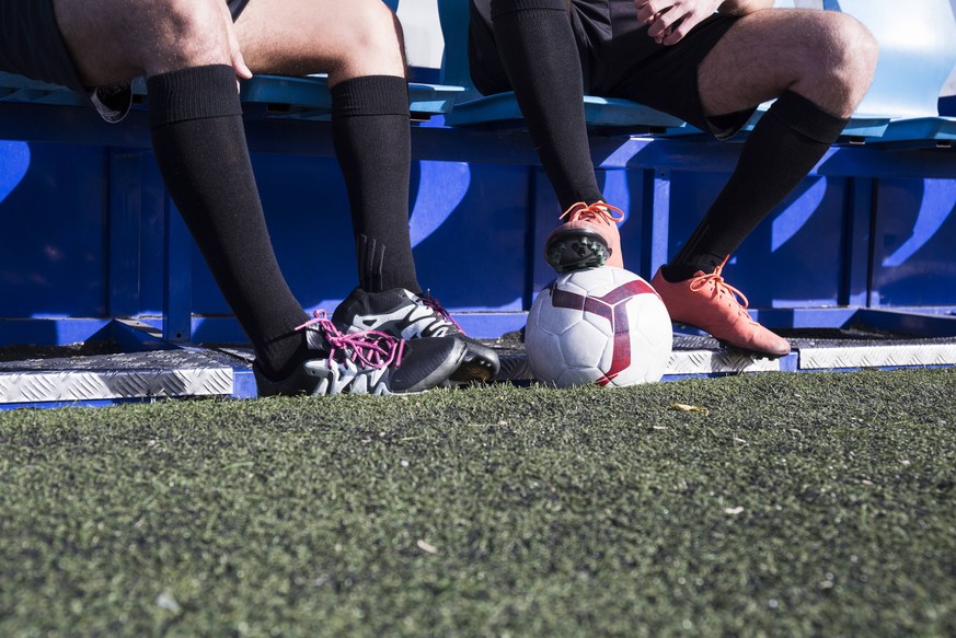 Legs of two football players sitting on bench at football field model released Symbolfoto property released PUBLICATIONxINxGERxSUIxAUTxHUNxONLY ABZF02178