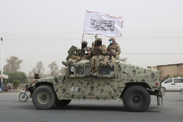 FILE - Taliban fighters patrol on the road during a celebration marking the second anniversary of the withdrawal of U.S.-led troops from Afghanistan, in Kandahar, south of Kabul, Afghanistan, Tuesday, ...