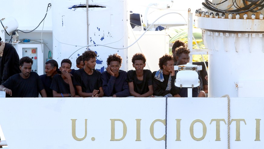 Migrants wait to disembark from the Italian coast guard vessel &quot;Diciotti&quot; at the port of Catania, Italy, August 22, 2018. REUTERS/Antonio Parrinello