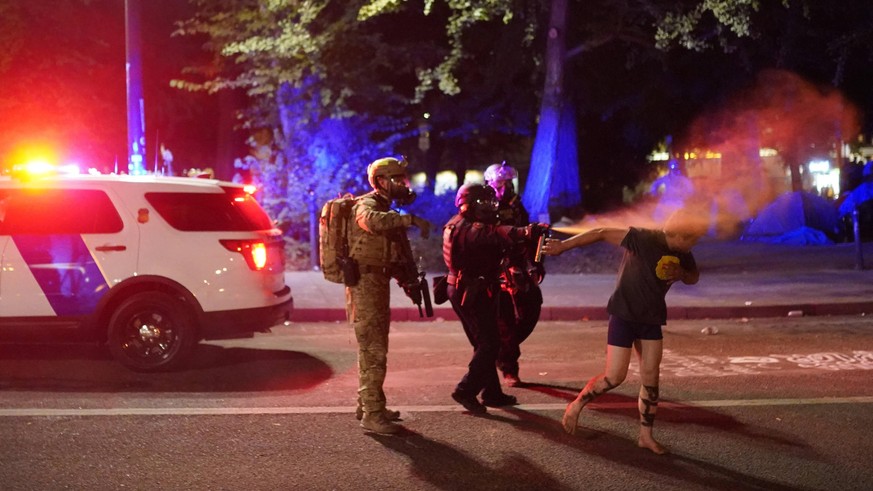 July 26, 2020, Portland, Oregon, USA: Federal officers pepper spray a protester after dispersing a crowd in front of the Mark O. Hatfield U.S. Courthouse in Portland, Ore., on Sunday. Portland USA - Z ...