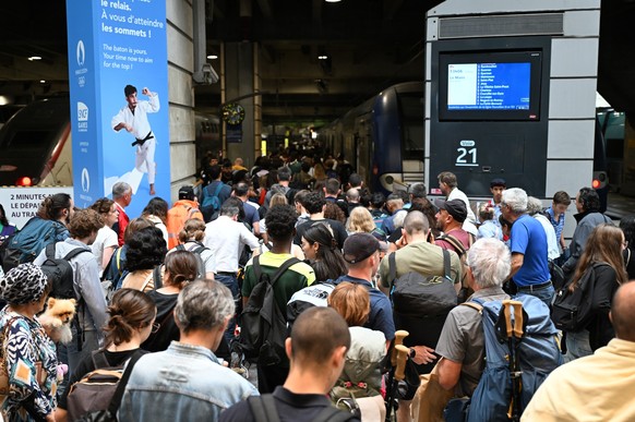 26.07.2024, Frankreich, Paris: Vor den Olympischen Sommerspielen, Olympia Paris 2024, Olympia, Zugreisende dr�ngen sich zu einem der wenigen Z�ge die vom Bahnhof Gare Montparnasse abfahren. Wenige Stu ...