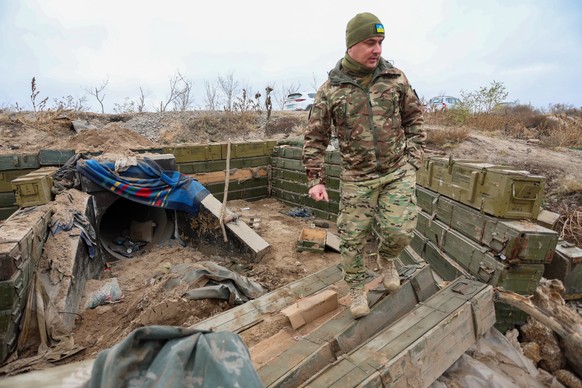 08.11.2022, Ukraine, Cherson: Ein ukrainischer Soldat begutachtet einen ehemaligen russischen Graben in der Oblast Cherson nahe der Frontlinie, während die russische Invasion in der Ukraine in ihren 2 ...