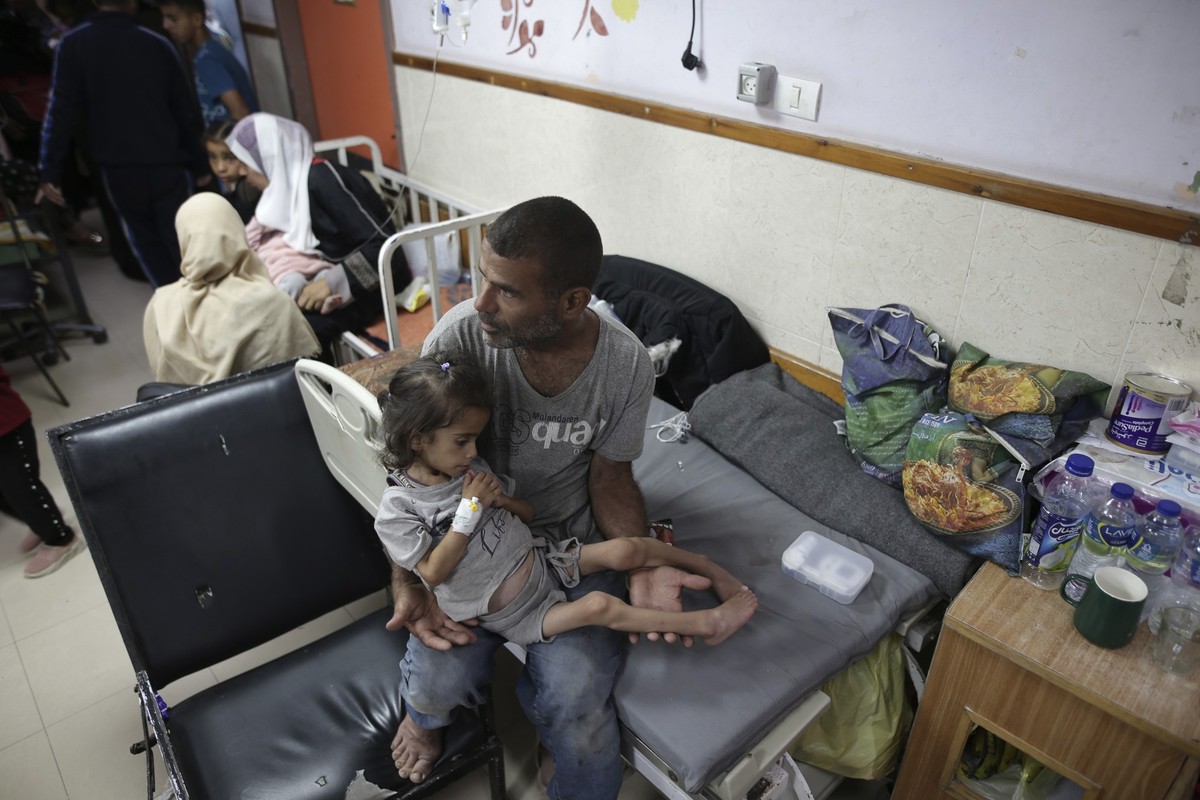 FILE - Abdulrahman Al-Rai holds his daughter Hana Al-Rai, 3, who suffers from diabetes, a weakened immune system and malnutrition at Al-Aqsa Martyrs Hospital in Deir al-Balah in the central Gaza Strip ...