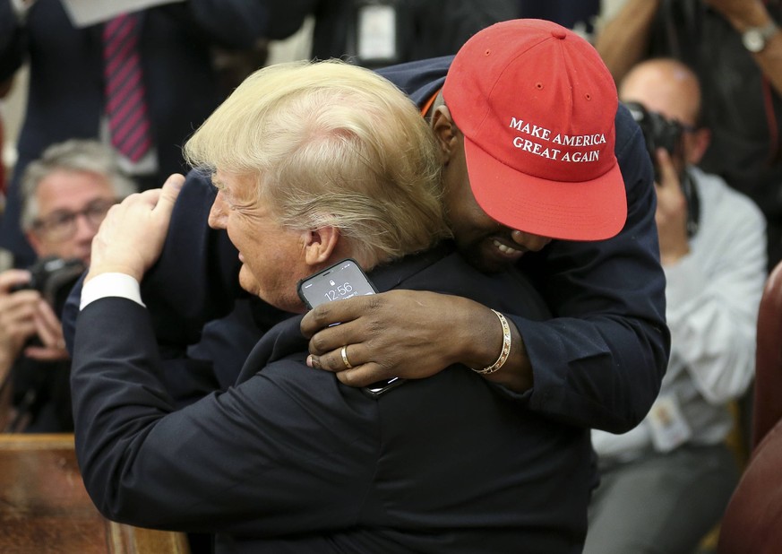 President Donald Trump hugs Kanye West during a meeting in the Oval office of the White House on October 11, 2018 in Washington, DC. Trump later signed the Music Modernization Act that protects copyri ...
