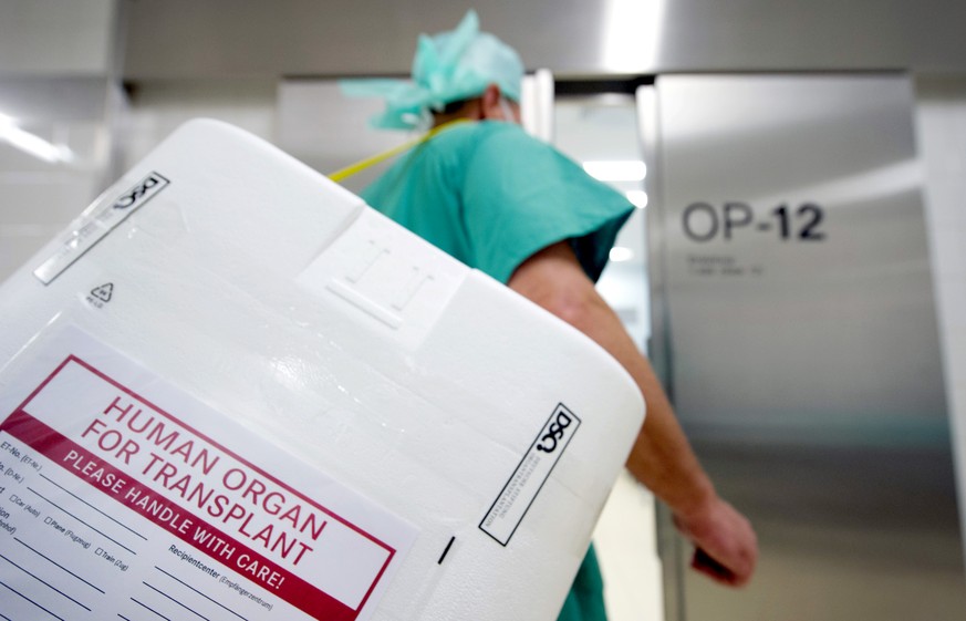 Ein Styropor-Behälter zum Transport von zur Transplantation vorgesehenen Organen wird am Eingang eines OP-Saales vorbeigetragen.