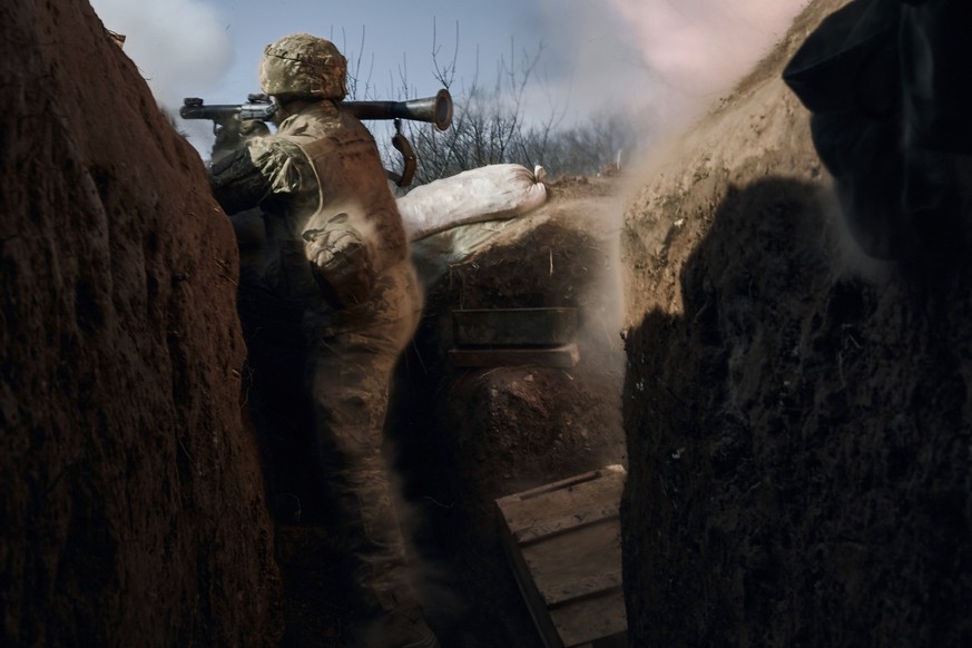24.03.2023, Ukraine, Bachmut: Ein ukrainischer Soldat der 28. Brigade feuert aus einem Granatwerfer an der Frontlinie während eines Gefechts mit russischen Truppen in der Nähe von Bachmut ab. Foto: LI ...