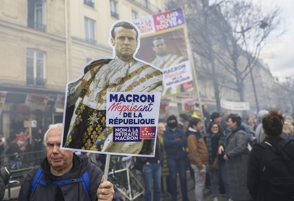 A protester holds a placard depicting as late king Louis XIV that reads, Macron contemptuous of the Republic,&quot; during a rally in Paris, Thursday, march 23, 2023. French unions are holding their f ...