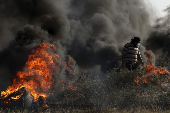 22.09.2023, Palästinensische Gebiete, Gaza: Ein palästinensischer Demonstrant verbrennt Reifen während Zusammenstößen mit israelischen Sicherheitskräften an der Grenze zu Israel. Israels Armee hat nac ...