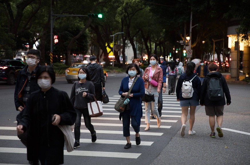 200330 -- TAIPEI, March 30, 2020 -- People wearing masks walk on street in Taipei, southeast China s Taiwan, March 30, 2020. The total number of novel coronavirus disease COVID-19 cases in Taiwan has  ...