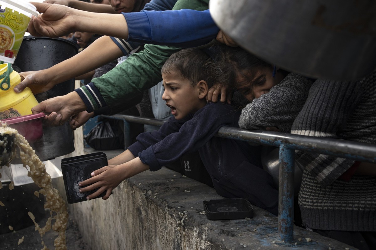 Palestinians line up for a free meal in Rafah, Gaza Strip, Thursday, Dec. 21, 2023. International aid agencies say Gaza is suffering from shortages of food, medicine and other basic supplies as a resu ...