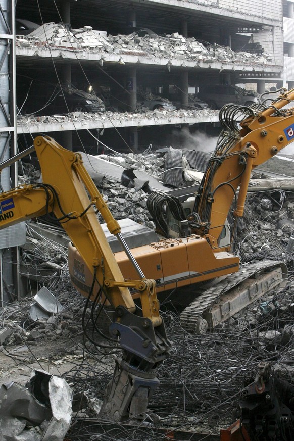 Bagger sind nach einem Bombenanschlag auf den Madrider Großflughafen dabei, die Trümmern eines Parkhauses zu beseitige