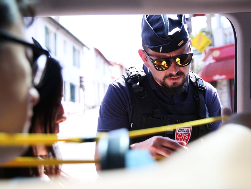 News Bilder des Tages (190823) -- BIARRITZ (FRANCE), Aug. 23, 2019 -- A policeman checks identity cards in Biarritz, southwestern France, on Aug. 23, 2019. Biarritz, the seaside resort in southwestern ...