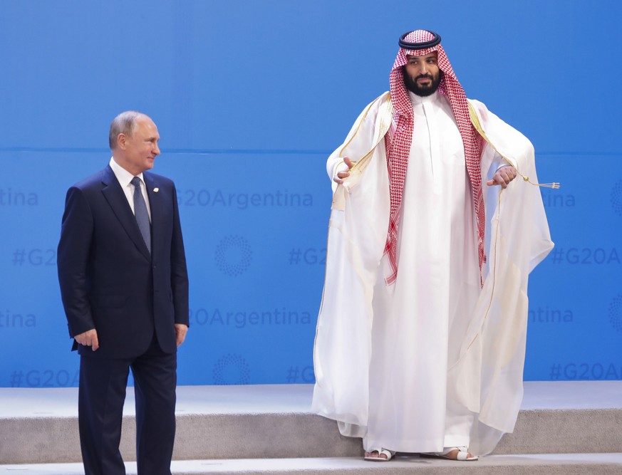 Russia&#039;s President Vladimir Putin, left, and Saudi Arabia&#039;s Crown Prince Mohammed bin Salman, right, wait for other heads of state for the group photo at the start of the G20 summit in Bueno ...