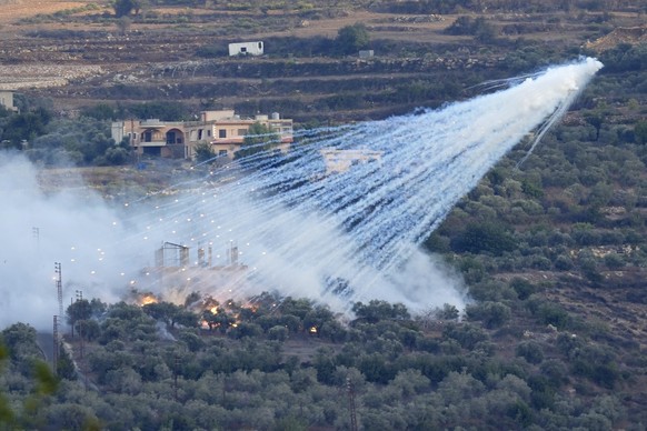 FILE - A shell that appears to be white phosphorus from Israeli artillery explodes over a house in al-Bustan, a Lebanese border village with Israel, south Lebanon, on Oct. 15, 2023. The human rights g ...